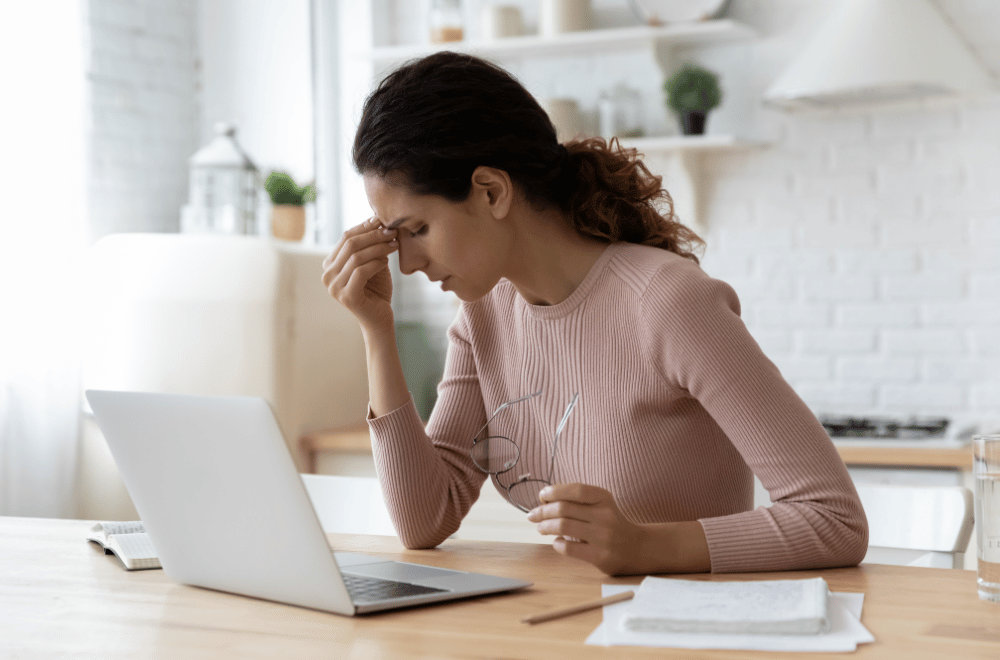 woman sitting at desk and looking uncomfortable