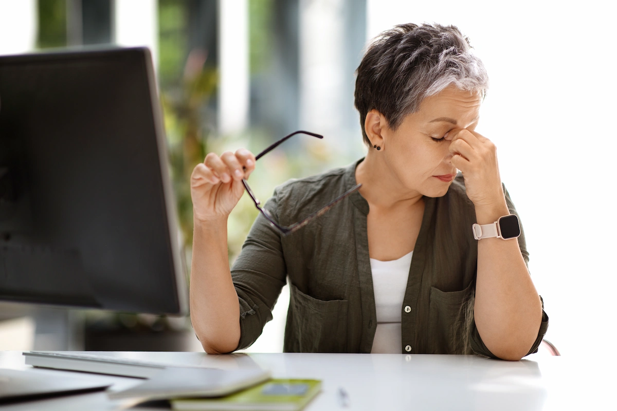 menopause-dry-eye Woman in office rubbing eyes